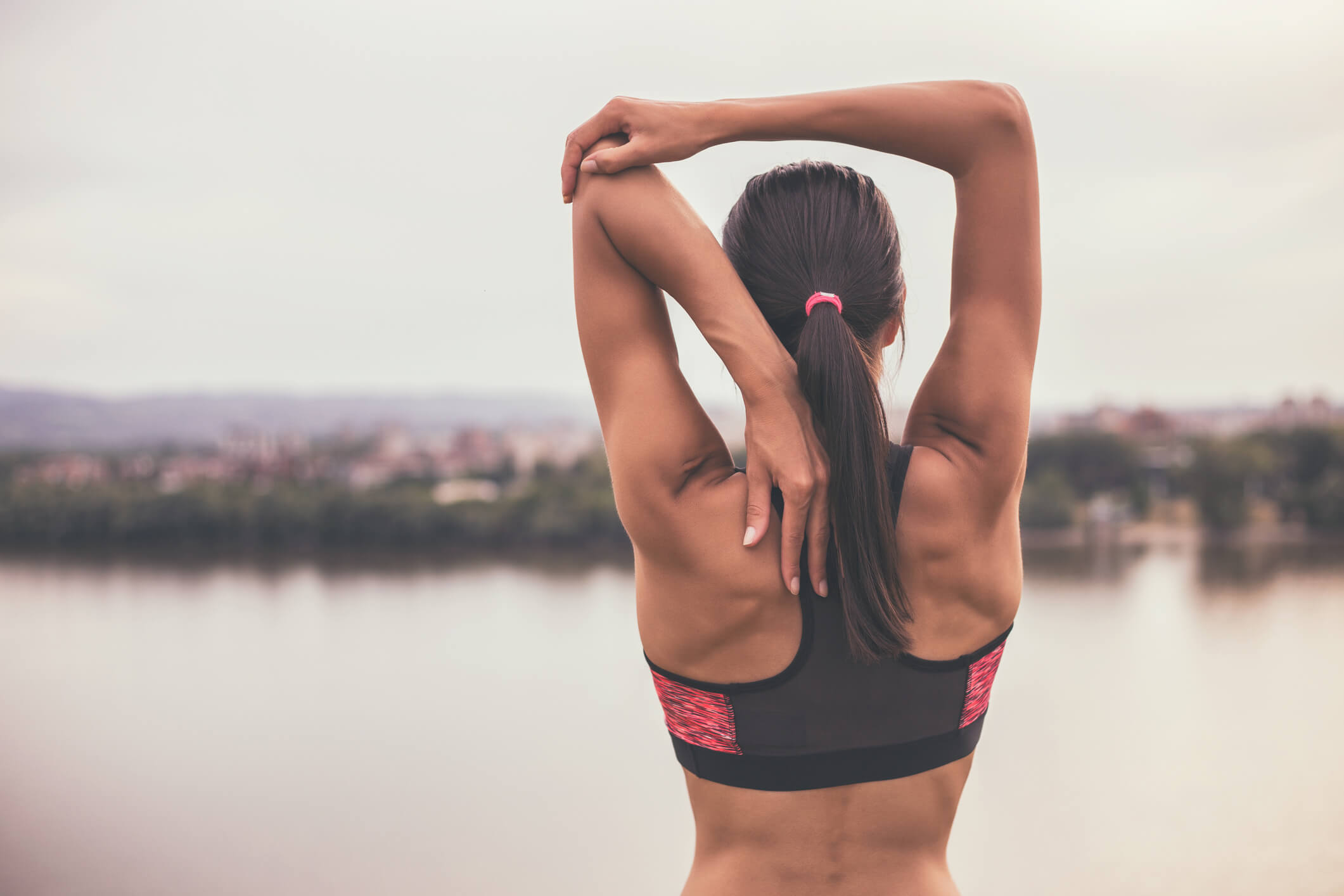 woman stretching along riverfront