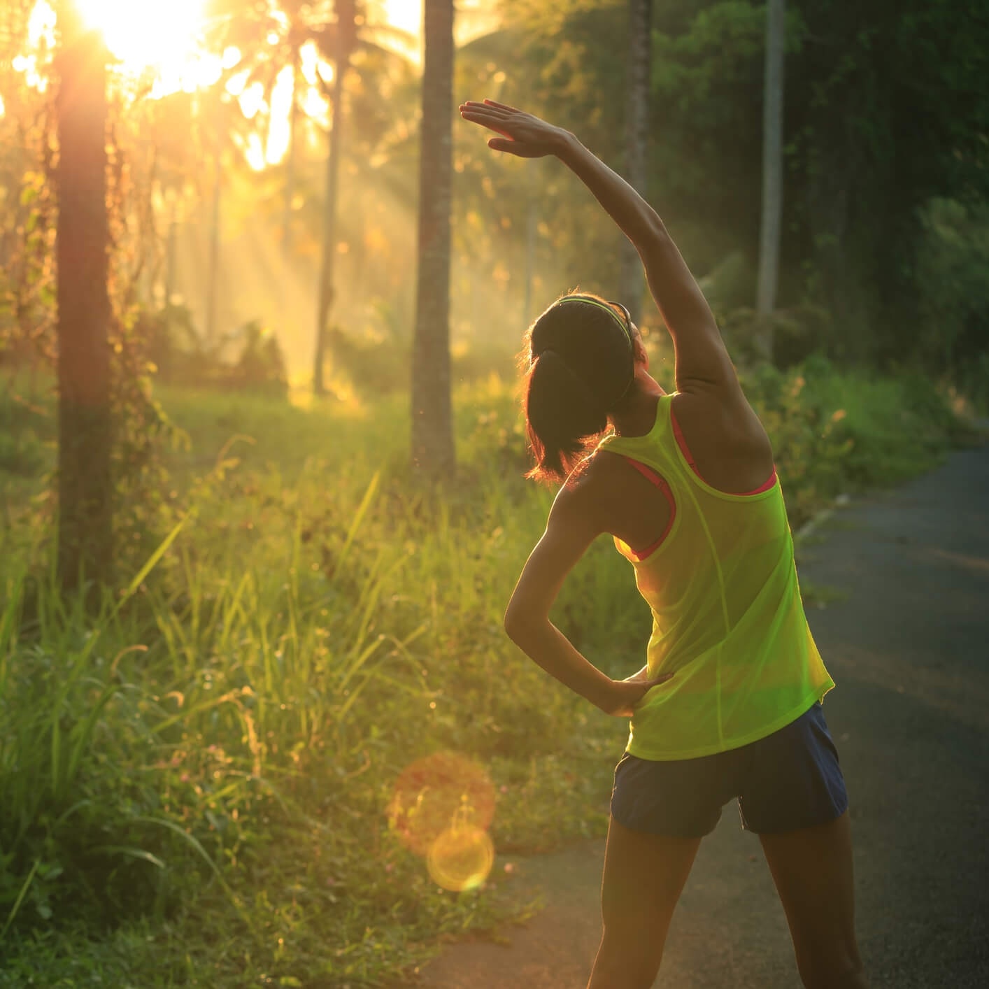 Woman stretching on path in woods