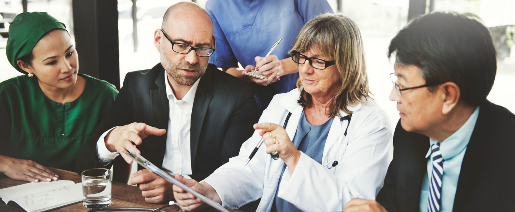 Doctors discussing notes at a conference table